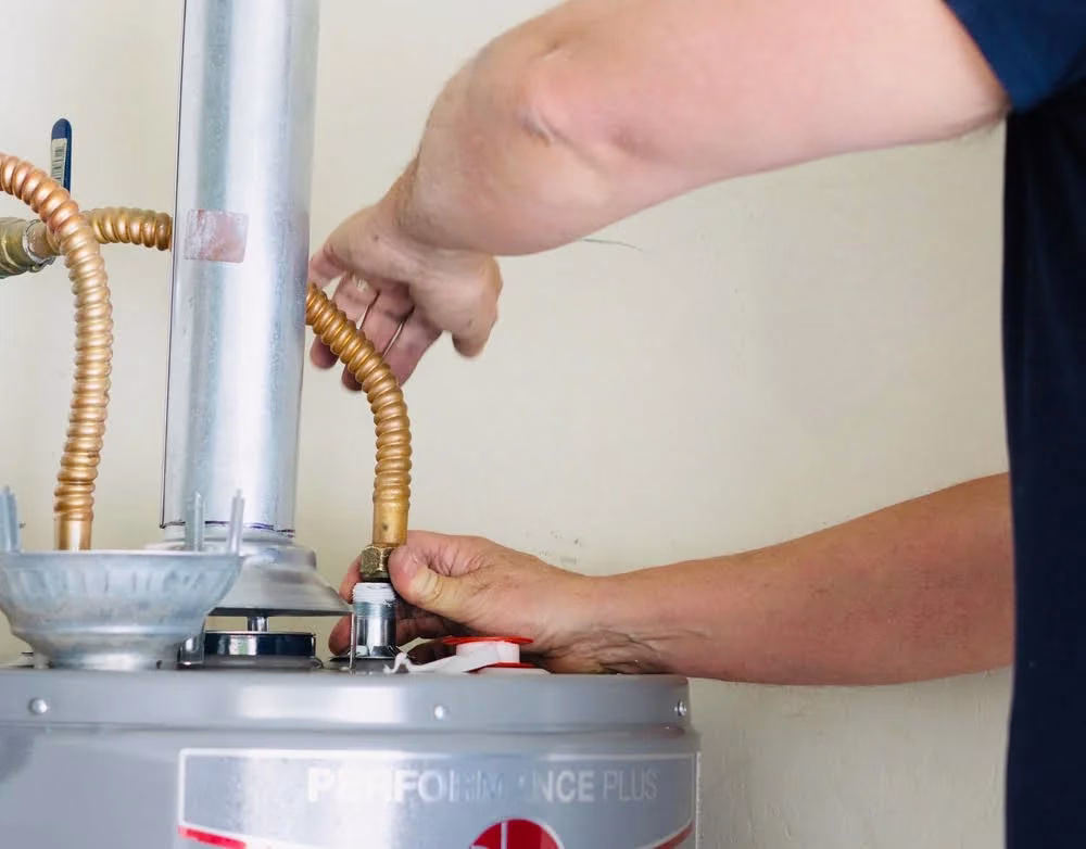 A plumber working on a water heater